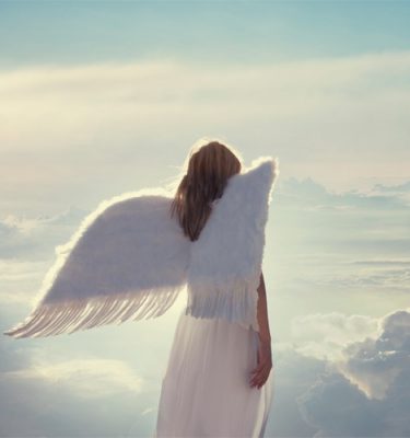 Female angel with wings floating among the clouds